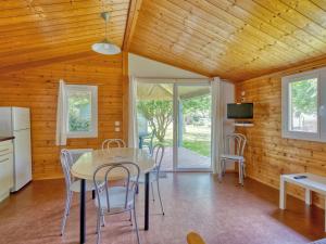 a kitchen and dining room with a table and chairs at Chalet 3 pièces Oléron 4 couchages SAINT DENIS DOLERON - FR-1-246A-360 in Saint-Denis-dʼOléron