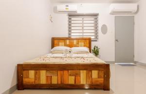 ein Holzbett in einem Zimmer mit Fenster in der Unterkunft Transcient House Trece Martires Home Sweet Home in Quintana