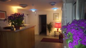 a room with purple flowers and a counter with a lamp at Almond Tree Hotel in Bicester