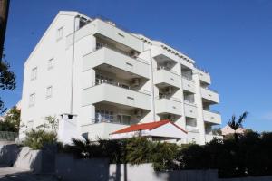 a white apartment building with a red roof at Villa Laurus in Kožino