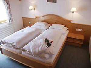 a bed with white sheets and flowers on it at Appartements Mattioli in Samnaun