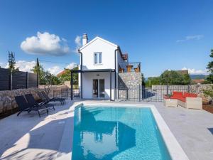 a swimming pool in front of a house at Luxury Krk Villa with Private Pool and Gardens - Three Bedroom Villa in Krk