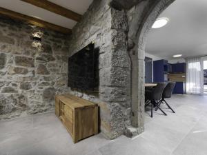 a living room with a stone wall with a fireplace at Luxury Krk Villa with Private Pool and Gardens - Three Bedroom Villa in Krk