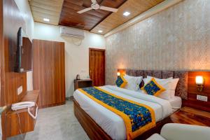 a bedroom with a large bed and a television at Hotel Relax Suites FNG Expresway 63 Noida in Noida +46 photos