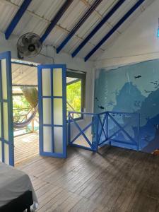 ネコクリにあるCabaña en Necocli Cerca al Marの青いドアと壁画のある寝室 +6枚の写真
