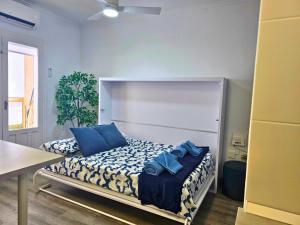 a bedroom with a bed with blue pillows on it at Studio Emilios Torrevieja in Torrevieja +26 photos