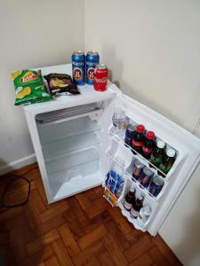 una nevera abierta llena de bebidas y refrescos en Kitnet na Princesa Isabel no 10 andar, en Río de Janeiro