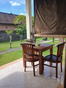 a wooden table and two chairs on a patio at Bumbung Bungalows in Amed