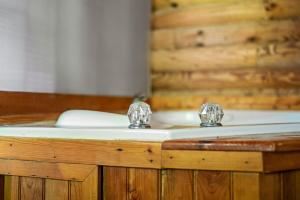 een bad met twee kranen erop bij Log Cabin, In-Room Jacuzzi, WiFi, Fireplace in Sevierville