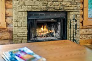 een open haard met een vuur erin bij Log Cabin, In-Room Jacuzzi, WiFi, Fireplace in Sevierville +32 foto's
