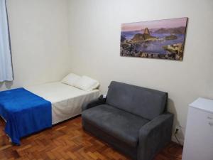 Un pequeño dormitorio con una cama y una silla. en Kitnet na Princesa Isabel no 10 andar, en Río de Janeiro