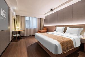 Una habitación de hotel con una cama grande y un escritorio. en Jiuzhaigou Mountain villa, en Jiuzhaigou