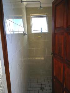 a bathroom with a shower and a window at Sunrise On Sea Backpackers in Port St. Johns