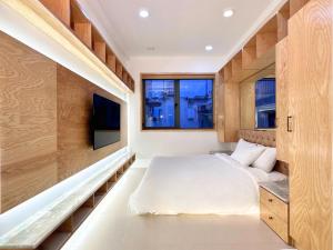 a bedroom with a bed and a tv in it at Leiden Homestay&Cafe' in Ho Chi Minh City
