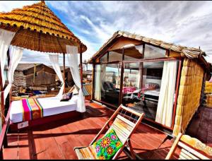 a bed and a chair on a deck with a gazebo at Titicaca posada del sol lodge in Puno +10 photos