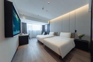 Llit o llits en una habitació de Atour X Hotel Xiamen Gaoqi Airport Huli Innovation Park Metro Station