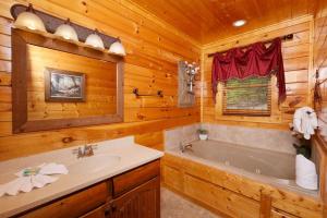 une salle de bain avec baignoire et lavabo dans une cabine dans l'établissement Award Winning Views, à Sevierville 43 autres photos