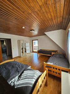 two beds in a room with a wooden ceiling at Mobilierte Monteuerswohnungen mit 6 Betten Stuttgart, Böblingen, Reutlingen, Waldenbuch - Gaiern1 in Waldenbuch