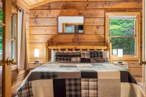 a bedroom with a bed in a wooden cabin at Hot Tub, Close to Everything, Honeymoon Cabin in Sevierville