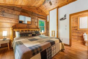 a bedroom with a bed and a bathroom with a tub at Hot Tub, Close to Everything, Honeymoon Cabin in Sevierville +29 photos