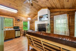 a living room with a leather bench in a log cabin at Hot Tub, Close to Everything, Honeymoon Cabin in Sevierville