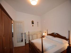 a bedroom with a bed with white sheets and a door at Villa in Valdora with Lake Maggiore Views in Ghiffa