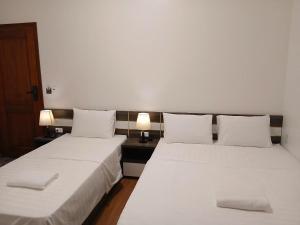 2 bedden in een kamer met witte lakens en kussens bij HoTel Ven Hồ in Thái Thụy