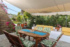 a patio with a wooden table and chairs at House Soko - 30m to Beach, near Mako and Elephant beach bar in Pefkohori