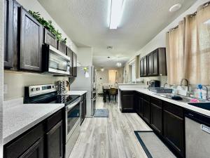 a kitchen with black cabinets and a white appliances at Green Meadow Homestay in San Antonio
