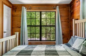 a bedroom with a bed and a large window at MTN Views, Hot Tub, WiFi, Sleeps 3 in Sevierville