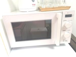 a white microwave oven sitting on top of a counter at HouseKL in Tokyo