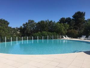 a large swimming pool with blue water at Riviera Home in Mandelieu-La Napoule