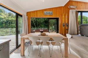 une salle à manger avec une table et des chaises en bois dans l'établissement Pukawa Haven - Pukawa Bay Holiday Home, à Kuratau