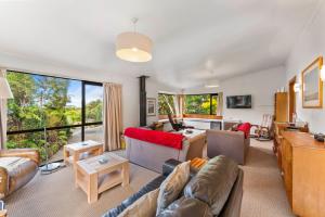 un salon avec un canapé et une table dans l'établissement Pukawa Haven - Pukawa Bay Holiday Home, à Kuratau