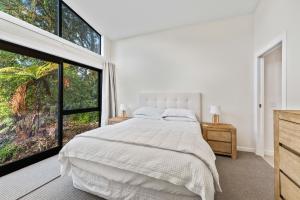 une chambre avec un lit et une grande fenêtre dans l'établissement Pukawa Haven - Pukawa Bay Holiday Home, à Kuratau