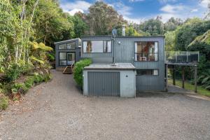 une petite maison au milieu d'une forêt dans l'établissement Pukawa Haven - Pukawa Bay Holiday Home, à Kuratau