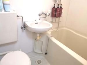 a bathroom with a sink and a toilet and a tub at HouseKL in Tokyo