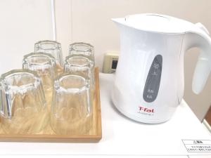 a white blender sitting on a counter with glasses at HouseKL in Tokyo