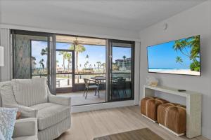 a living room with a chair and a tv and a table at Pointe Santo C1 in Sanibel