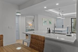 a white kitchen with a sink and a table at Pointe Santo C1 in Sanibel +50 photos