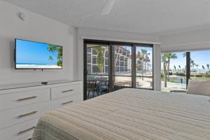 a bedroom with a bed and a flat screen tv at Pointe Santo C1 in Sanibel