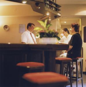 un grupo de personas sentadas en un bar en Hotel Jedermann en Múnich