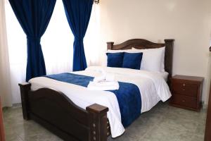 a bedroom with a large bed with blue curtains at Hotel San Lorenzo Ubaté in Ubaté
