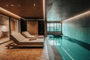 a living room with a couch and a swimming pool at Sagredo Boutique Hotel & Spa in Ágios Fokás