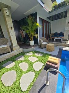 Un patio con piscina y un patio con césped. en Villa Mustika, en Ubud