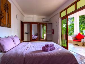 a bedroom with a large bed with purple towels on it at Villa Formosa Panglao in Panglao Island