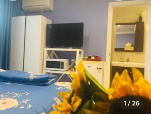 a room with a bed with yellow flowers and a tv at Nice room less pay near Port Adelaide in Rosewater