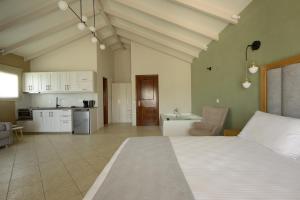 a large bedroom with a white bed and a kitchen at Villa Apollo in Parga