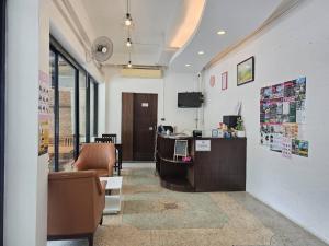 an office with a reception desk and chairs in a room at Jonah Hotel in Chiang Mai