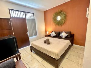 a bedroom with a bed and a flat screen tv at Simon Homestay in Sanur